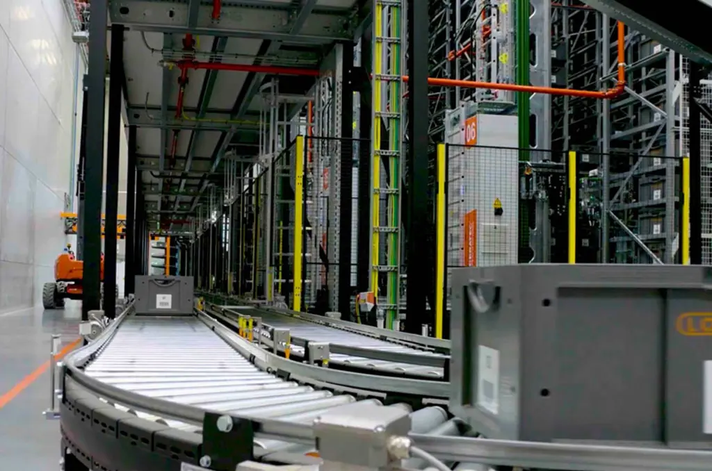 Automated warehouse sortation equipment with conveyor line and safety fencing for secure and efficient material handling