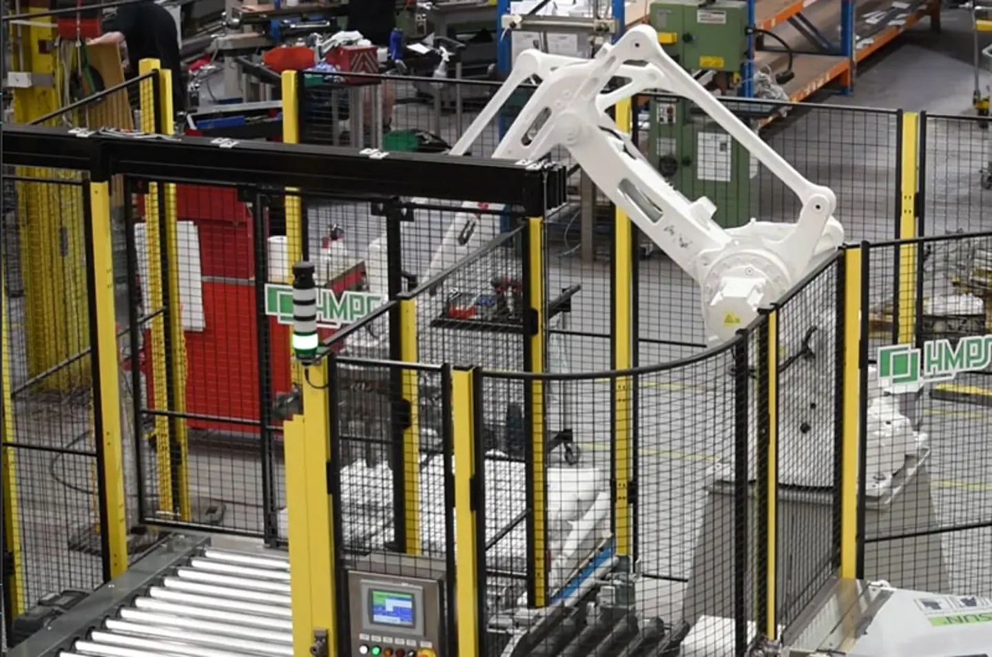 High-speed robotic palletiser stacking cases on pallets inside protected area
